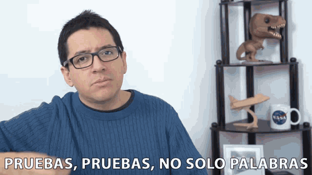 a man wearing glasses and a blue sweater says pruebas