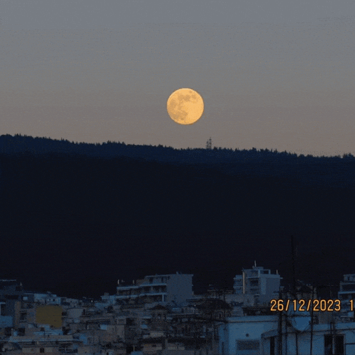 a full moon is visible over a city on december 26th