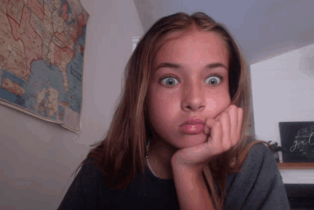 a girl is making a funny face in front of a map of the united states of america