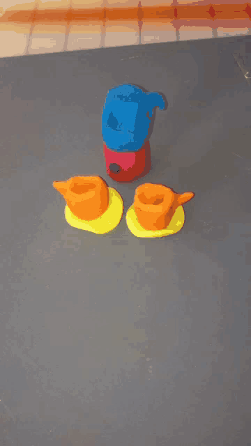 three cups and a pitcher made out of play dough on a table