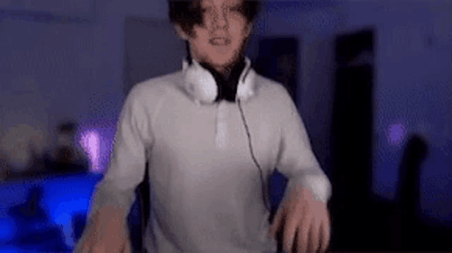 a young man wearing headphones is standing in front of a dj controller .