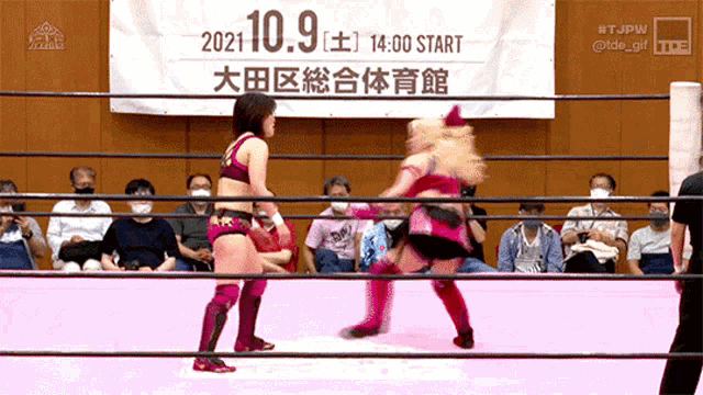 two women are wrestling in a ring with a banner that says 2021.10.9