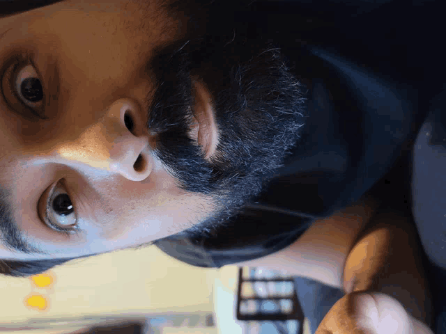 a close up of a man 's face with a beard and a black shirt