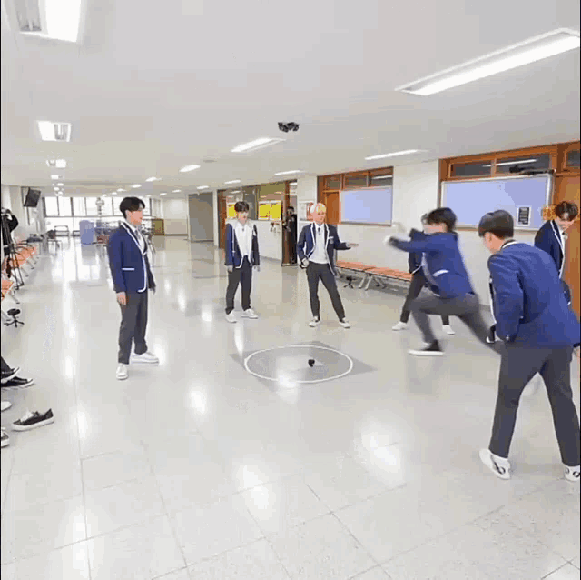 a group of young men are playing a game in a hallway with landing like a hero written in korean