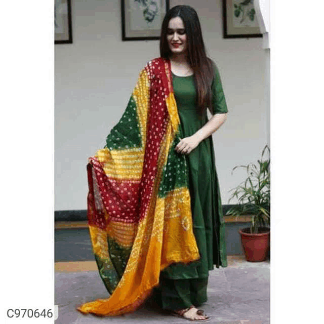 a woman is wearing a green dress with a red , yellow , and green dupatta .