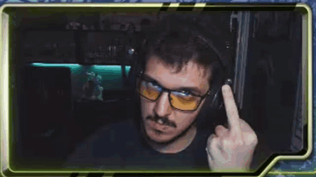 a man wearing headphones and glasses is giving the middle finger in a video chat .