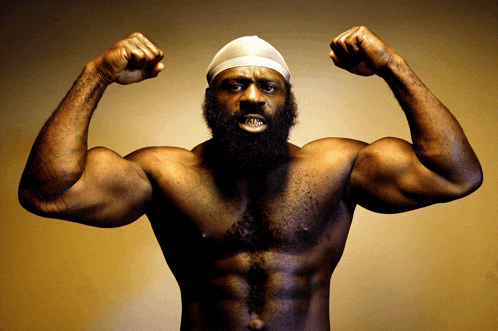 a shirtless man with a beard and a bandana on his head is flexing his muscles