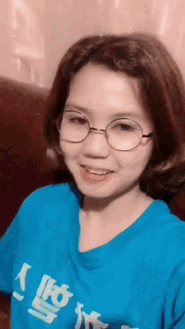 a woman wearing glasses and a blue shirt with chinese writing