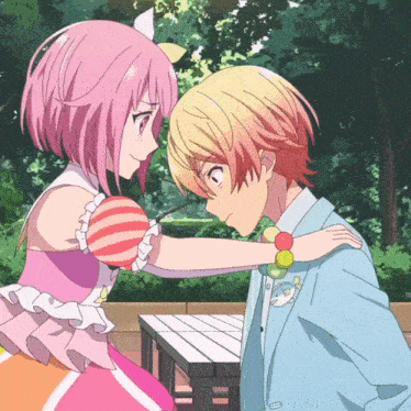 a boy and a girl are looking at each other and the girl is wearing a pink dress