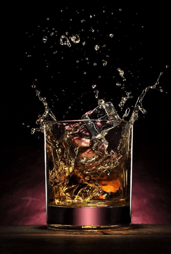 a glass of whiskey with a splash of ice