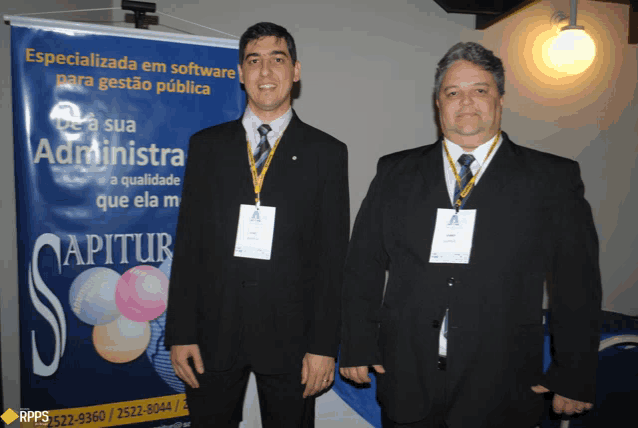 two men are standing in front of a banner that says " apitur "