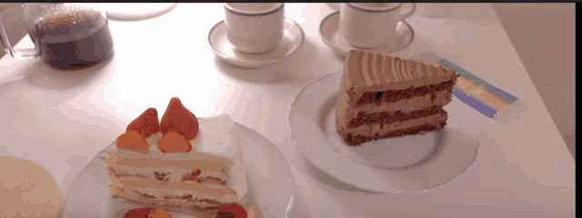 two slices of cake on white plates on a table with cups of coffee