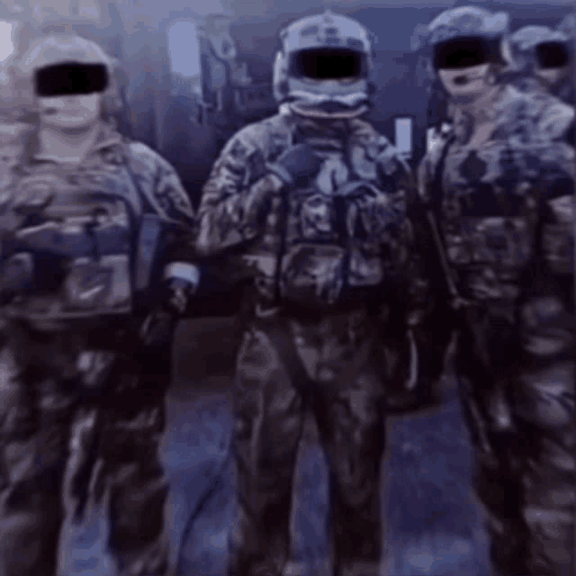 a group of soldiers are standing next to each other with their faces covered