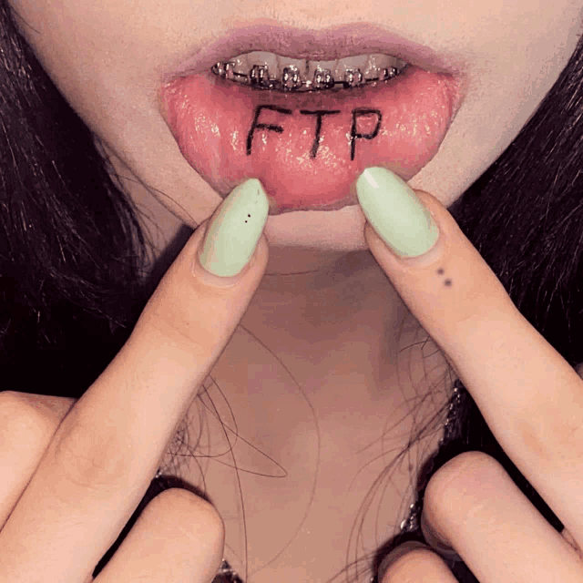 a woman with braces on her teeth has the word ftp written on her lip