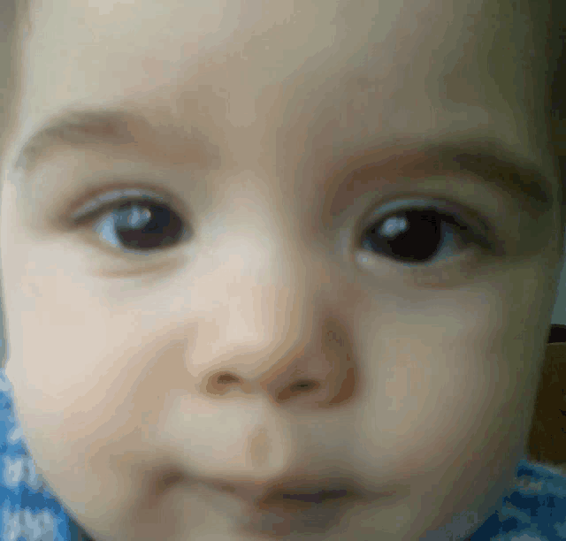 a close up of a baby 's face with a blurred background