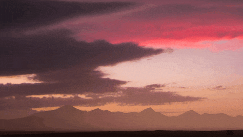 a sunset sky with mountains in the background