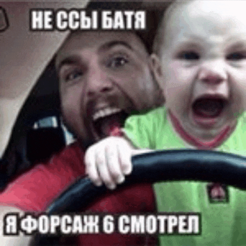 a man is driving a car while holding a baby .