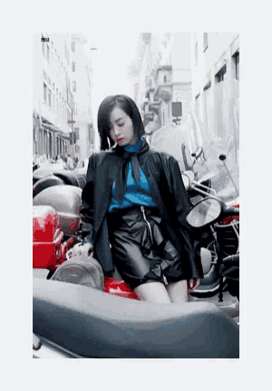 a woman in a blue sweater and black skirt is sitting on a motorcycle .