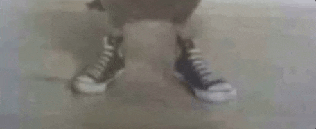 a close up of a person 's feet wearing converse shoes .