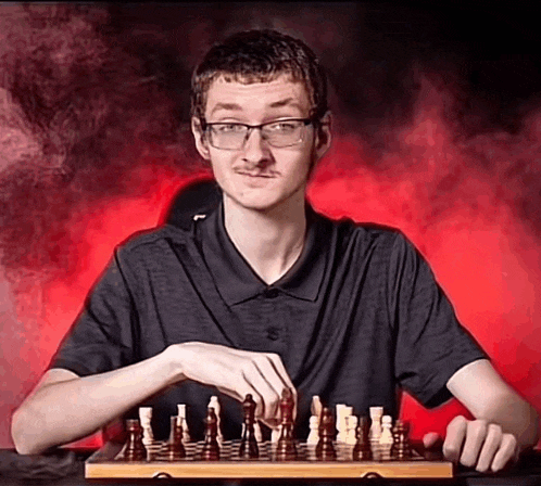 a man is playing a game of chess with a mustache and glasses .