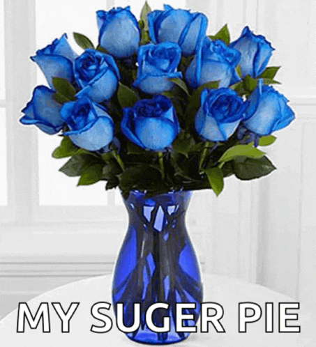 a blue vase filled with blue roses has the words my suger pie below it