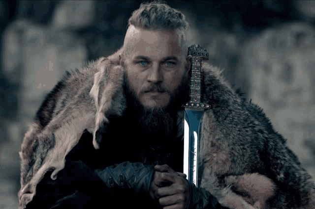 a man with a beard is holding a sword