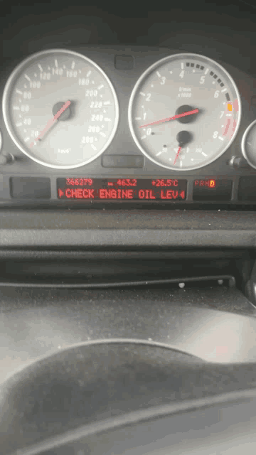 a car dashboard displays a check engine oil lev