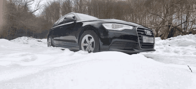 a black audi is parked in the snow with a license plate