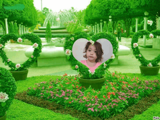 a picture of a little girl in a heart shaped frame in a garden