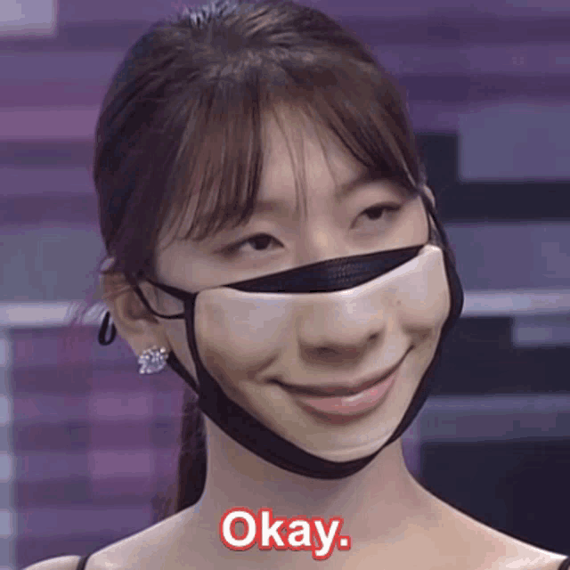 a woman wearing a face mask with okay written on the bottom