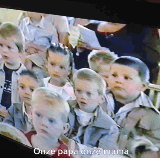 a group of children are sitting in front of a screen that says " onze papa onze mama " on it