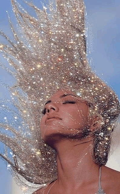 a close up of a woman 's face with sparkles on her hair