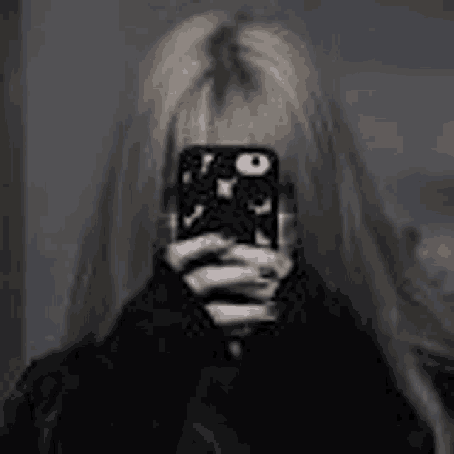 a woman is taking a picture of herself with her phone .