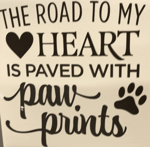 a sign that reads " the road to my heart is paved with paw prints "