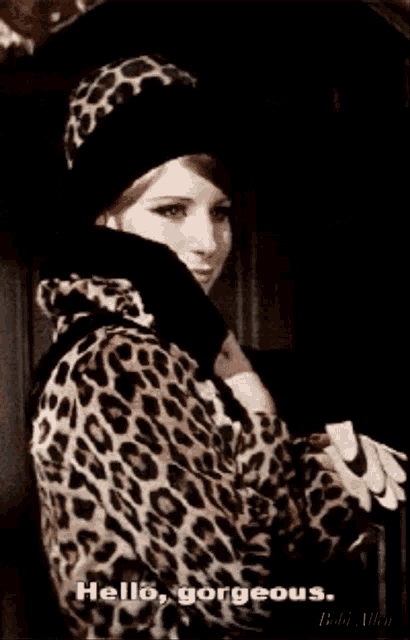 a woman wearing a leopard print coat and hat says " hello gorgeous "