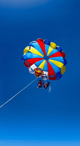 two people are parasailing with a parachute that has superman on it