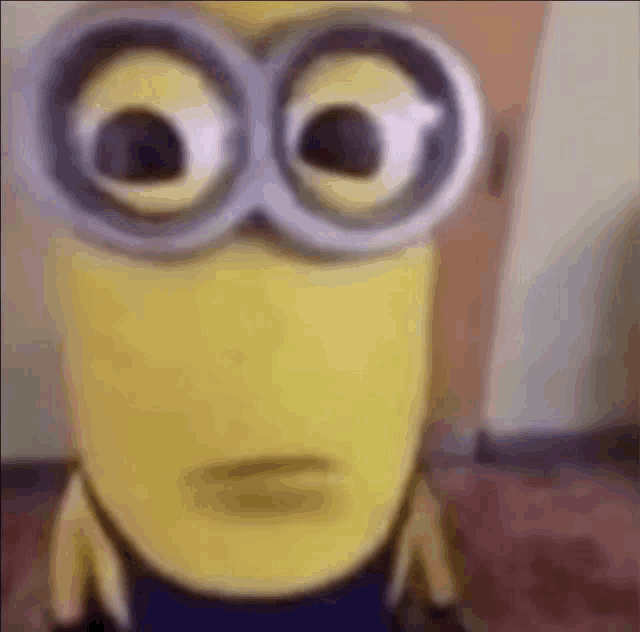 a close up of a minion wearing goggles and making a face .