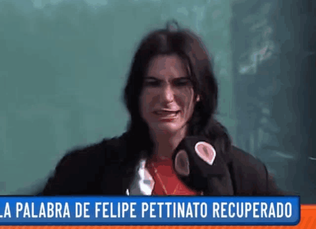 a woman is crying in front of a green board and a sign that says la palabra de felipe pettinato recuperado