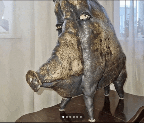 a statue of a pig 's head is on a wooden table