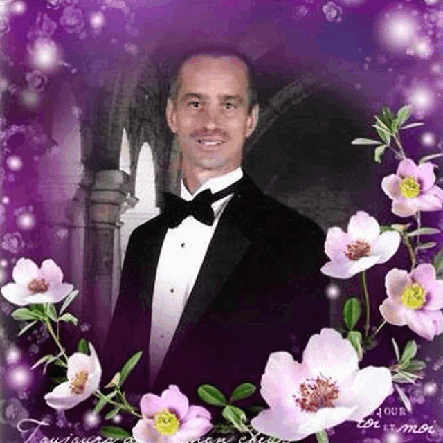 a man in a tuxedo is surrounded by pink flowers