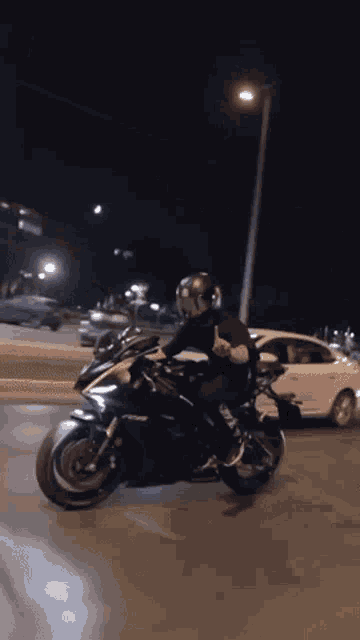 a man is riding a motorcycle at night and giving the middle finger