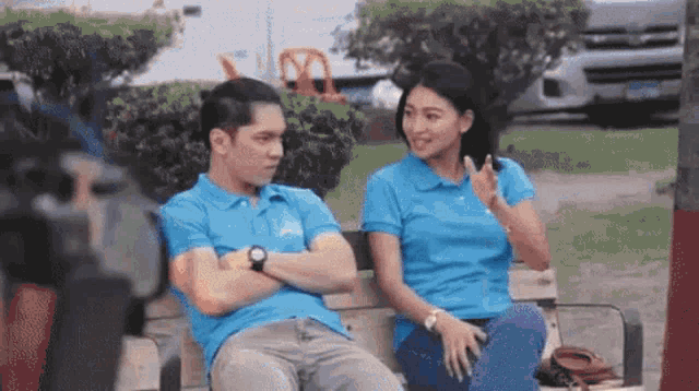 a man and a woman are sitting on a bench and talking to each other .