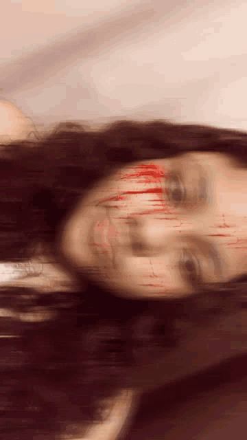 a blurry image of a woman with blood on her face