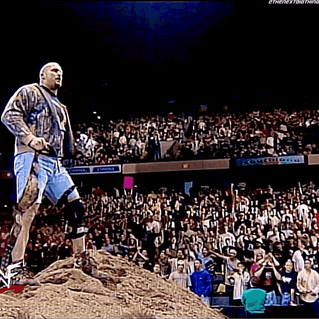 a man standing on top of a pile of dirt in front of a crowd with a sign that says south gate