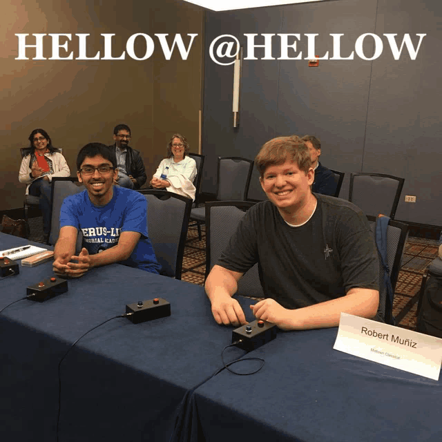 two men sit at a table with a sign that says " robert mueller "