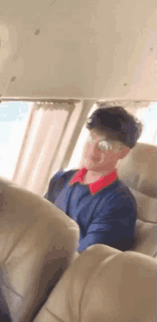 a man is sitting in the back seat of a car wearing sunglasses .