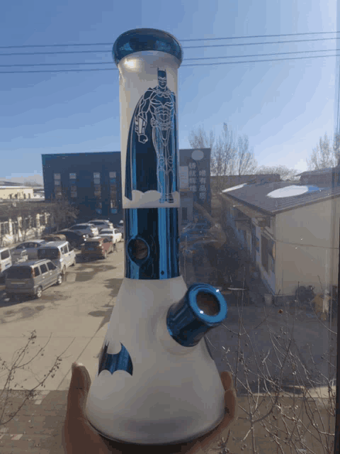 a person holding a bong with a batman design on it