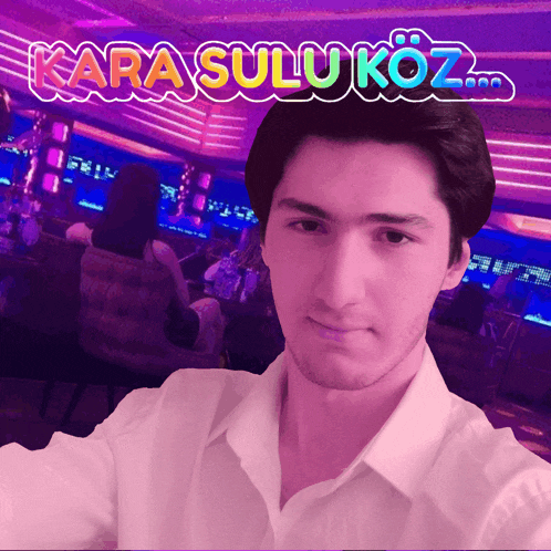 a man takes a selfie in front of a sign that says kara sulukoz