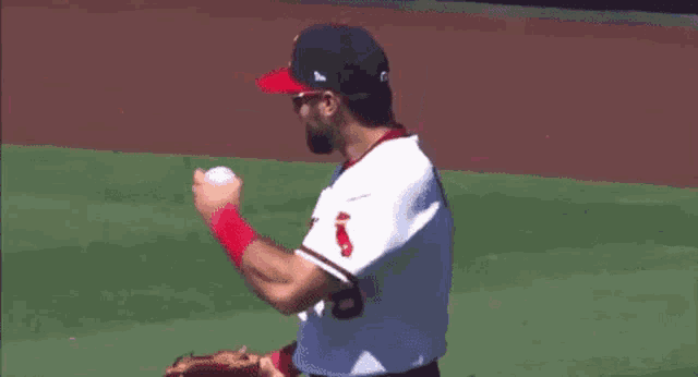 a baseball player wearing sunglasses and a white jersey with the word angels on it is standing on a baseball field .