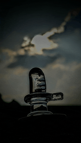 a black and white photo of a statue of a man with a cloudy sky in the background